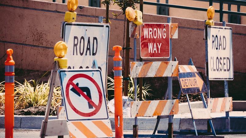 Blog Post by Anadi Misra on Agile Transformation failed strategies with image banner of Road closed signs on a road.